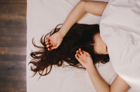 woman in bed with blanket over her head