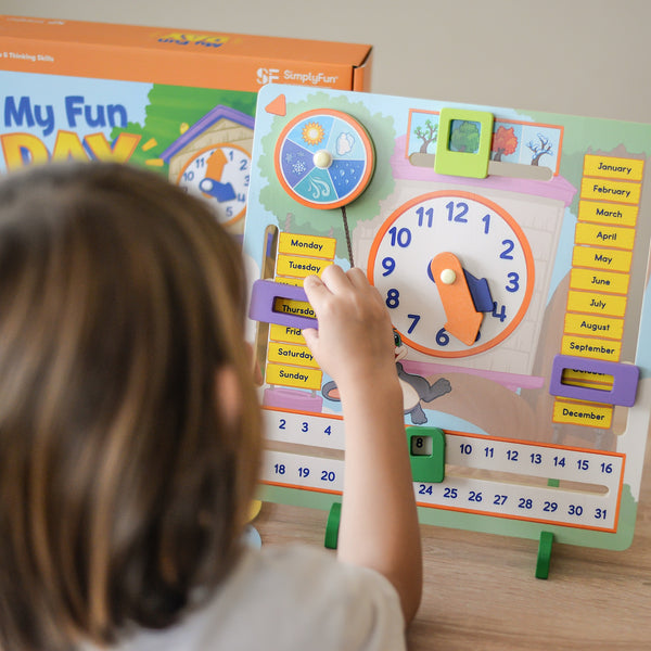 Preschooler boy learning to tell time with SimplyFun's My Fun Day Activity Board.
