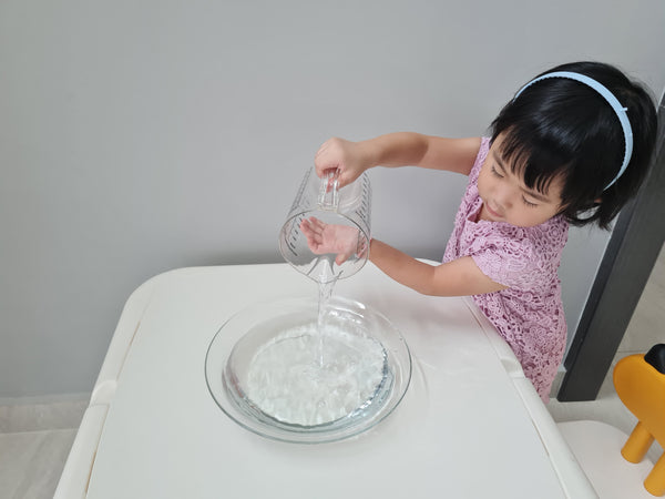 kid pouring water into a container