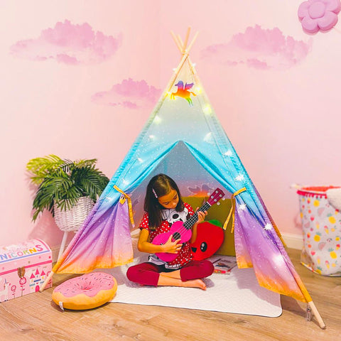 Girl play with guitar in a teepee tent