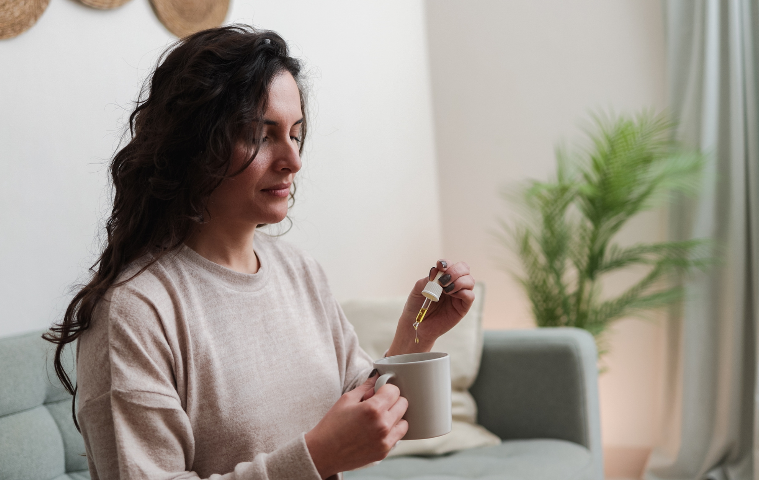 Woman adding CBD Oil Drops to a mug