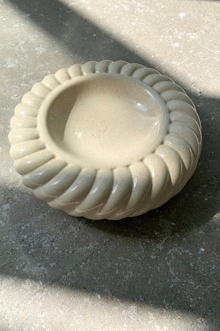 Original vintage Tommaso Barbi skål i riflet sandfarvet keramik. Skålen er håndlavet i Italien, 1970erne, og er signeret i bunden. Skålen har ingen afslag i glasuren. Tommaso Barbi er en anerkendt italiensk designer, som særligt i 1970erne udformede finurlige og fantasirige lamper samt møbler