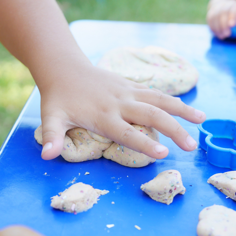 Child's hand pressing down to make a clay hand print