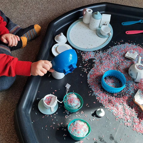 Toddler enjoying playing with a tea party messy makes tray