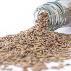 cumin seeds from a glass jar on a white background