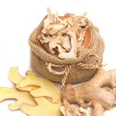 fresh ginger and a brown jute bag full of dry ginger on a white background