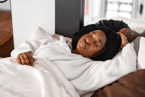 jeune-femme-noire-avec-un-bonnet-en-satin-dormant-dans-son-lit