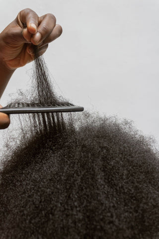 cheveux-afro-coiffés-par-une-main-de-femme-noire-tenant-un-peigne-afro