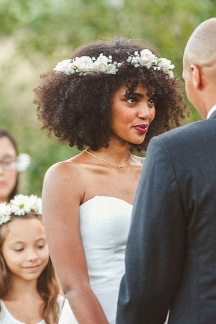 femme-métisse-aux-cheveux-frisés-habillée-avec-une-robe-de-mariée-blanche-se-tenant-devant-l'autel