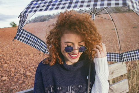 jeune-femme-aux-cheveux-bouclés-dans-un-champ-en-automne