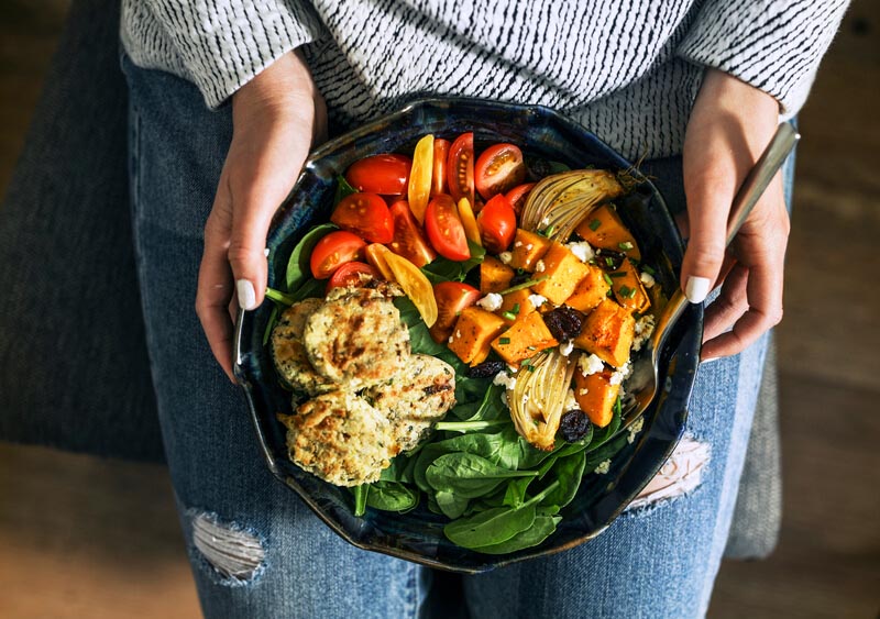 Frau hält ein veganes Gericht in den Händen