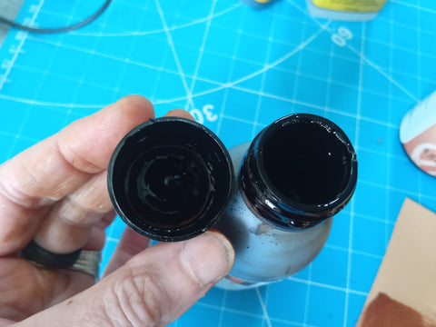 Image showing open dye bottle and lid and the excess around the neck