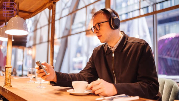 A person wearing noise-cancellation headphones in a crowded place