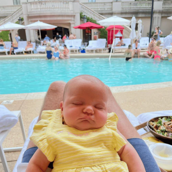 Baby sleeping with pool in background