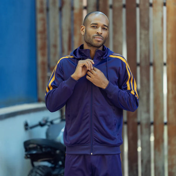 a man wearing a purple tracksuit with orange stripes