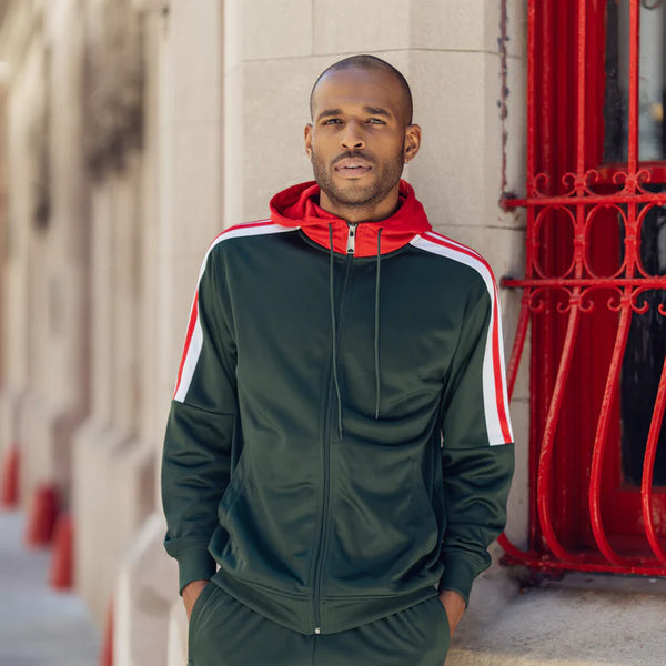 a man wearing an olive green tracksuit with white and red stripes.