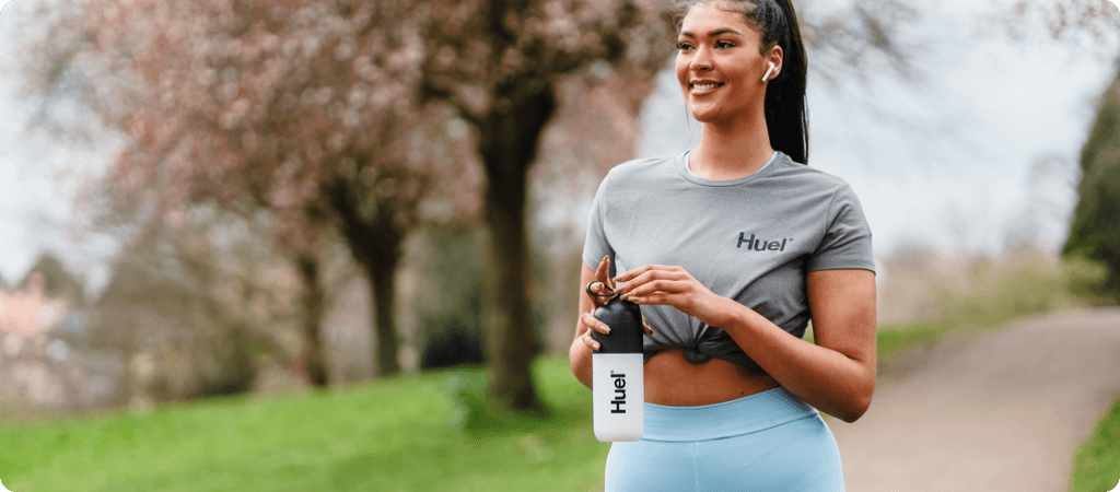 woman exercising outdoors with water bottle