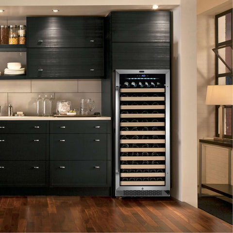 A black cabinet stainless steel trimmed door single zone right-hand hinge wine cooler with wooden shelves set in a freestanding setting with black cabinetry background