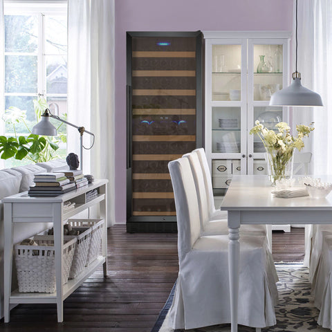 A black door dual zone right hand hinge wine cooler with hardwood shelves set in a freestanding mode in an all-white dining room