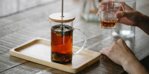 Herbal tea being brewed in a glass infuser