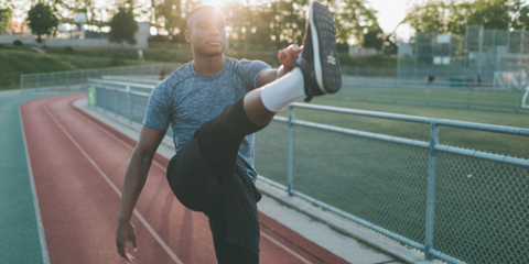 A track athlete stretching on the track