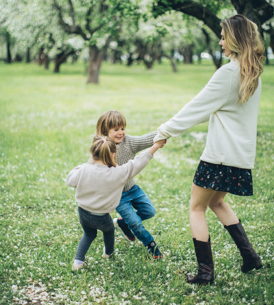 Mother with Young Boy and Girl Children Holding Hands in Park