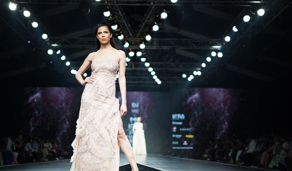Female Model in White Dress Posing On Catwalk at Fashion Week