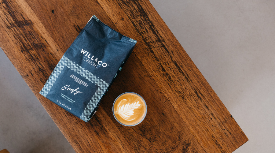 A bag of Will & Co's Goofy specialty coffee next to a freshly brewed cup of coffee