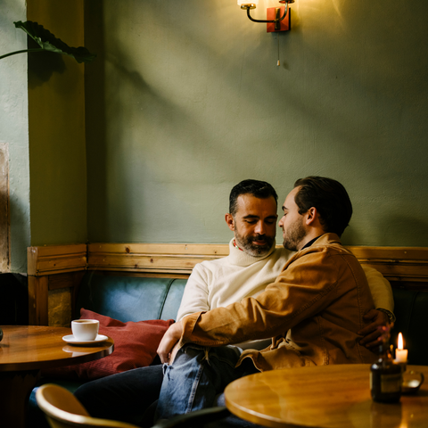 A confident gay man, dressed stylishly and sipping a cocktail at a trendy bar, ready for his post-breakup date. The blog post from Wicked Fox offers essential dos and don'ts for dating after a breakup.