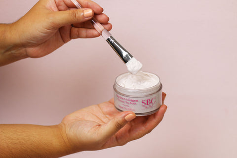 Hand dipping mask brush into Hydra-Collagen Creamy Clay Mask