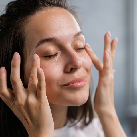 Woman applying moisturiser