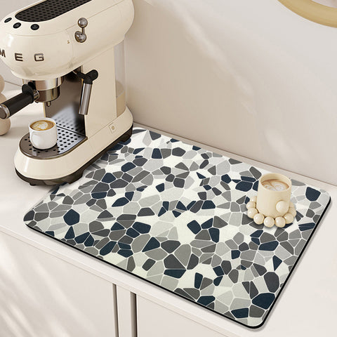 A cup of coffee sits on Matace's lovely coffee mat, which also features a minimalist coffee machine.
