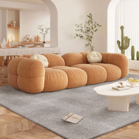 In a cream-style living room, Matace gray carpet tiles of long hair lay beneath soft yellow sofas.