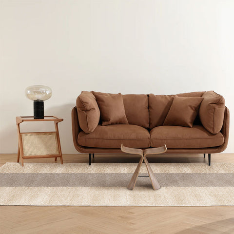 In a log-neutral living room, Matace beige and brown long-haired carpet tiles are laid out under small sofas.