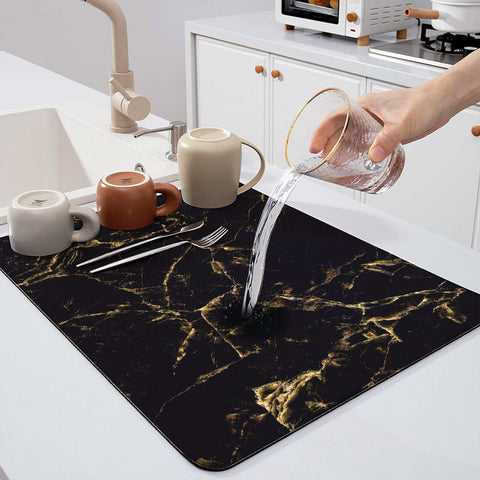 In an Instagram-style kitchen, some cups and forks are placed on Matace dish drying mats, and a cup filled with water is being poured onto dish drying mats.