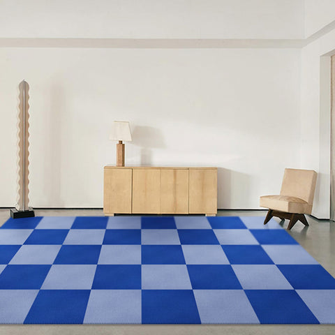 In an empty living room, Matace dark blue with light blue carpet squares lay on the ground.