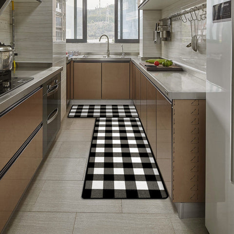 Inside a wood-style kitchenette, a Matace farmhouse black and white checkered Kitchen Rug is laid on the ground.