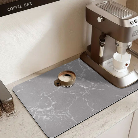 Matace coffee pot mat for countertops lies under a golden coffee machine.