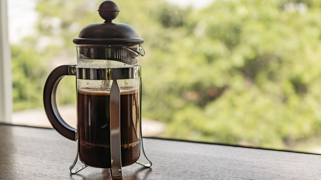 A french press with aerial resupply coffee outside in the forest