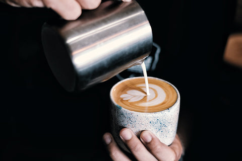 pouring milk for a macchiato