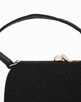 Vintage black corde top handle purse featuring abstract tone on tone pattern and asymmetrical closure and mini change purse.