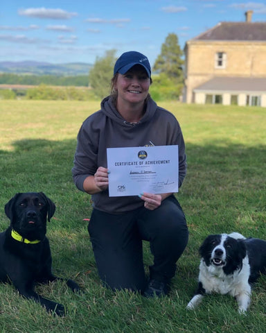 Girl kneeling with two dogs. Holding a certificate