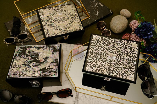 On the table are three mother-of-pearl boxes with different patterns.