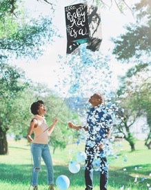 Blue confetti rains on a happy couple for a confetti gender reveal