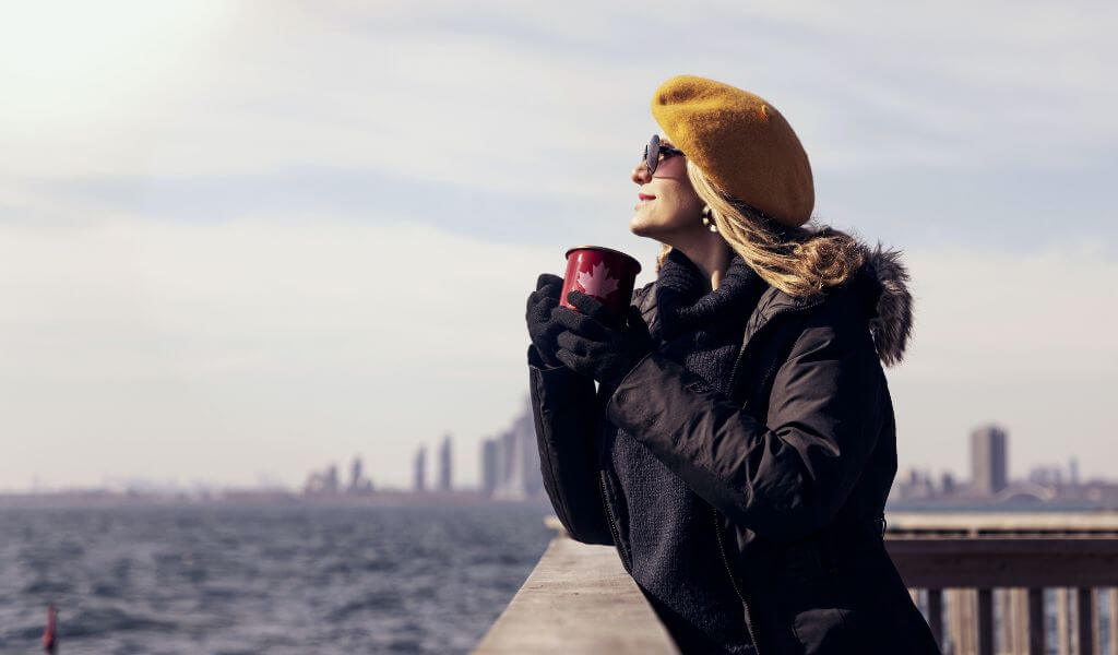 Femme devant la ville de New York en tenue chaude d'hiver avec un béret jaune 