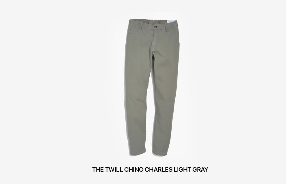 Un par de pantalones chinos gris claro para hombre.