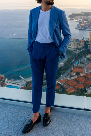 homme-en-costume-bleu-sur-balcon-avec-paysage-urbain