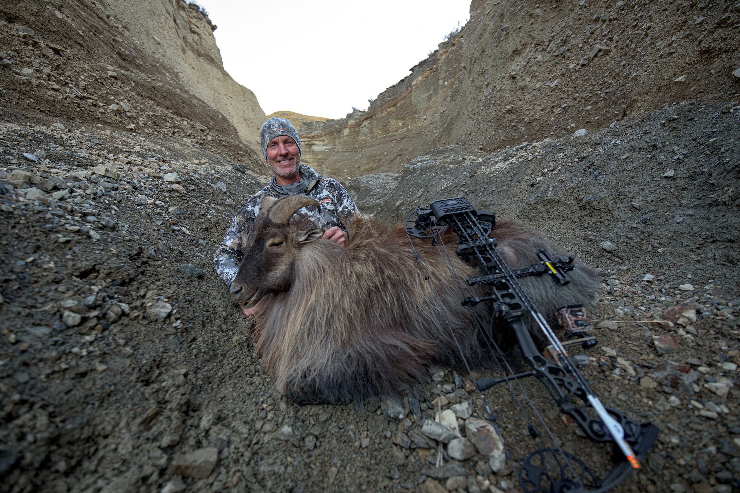 Rob sits with the first of two bull tahr he successfully harvested in New Zealand with his Mathews Halon bow