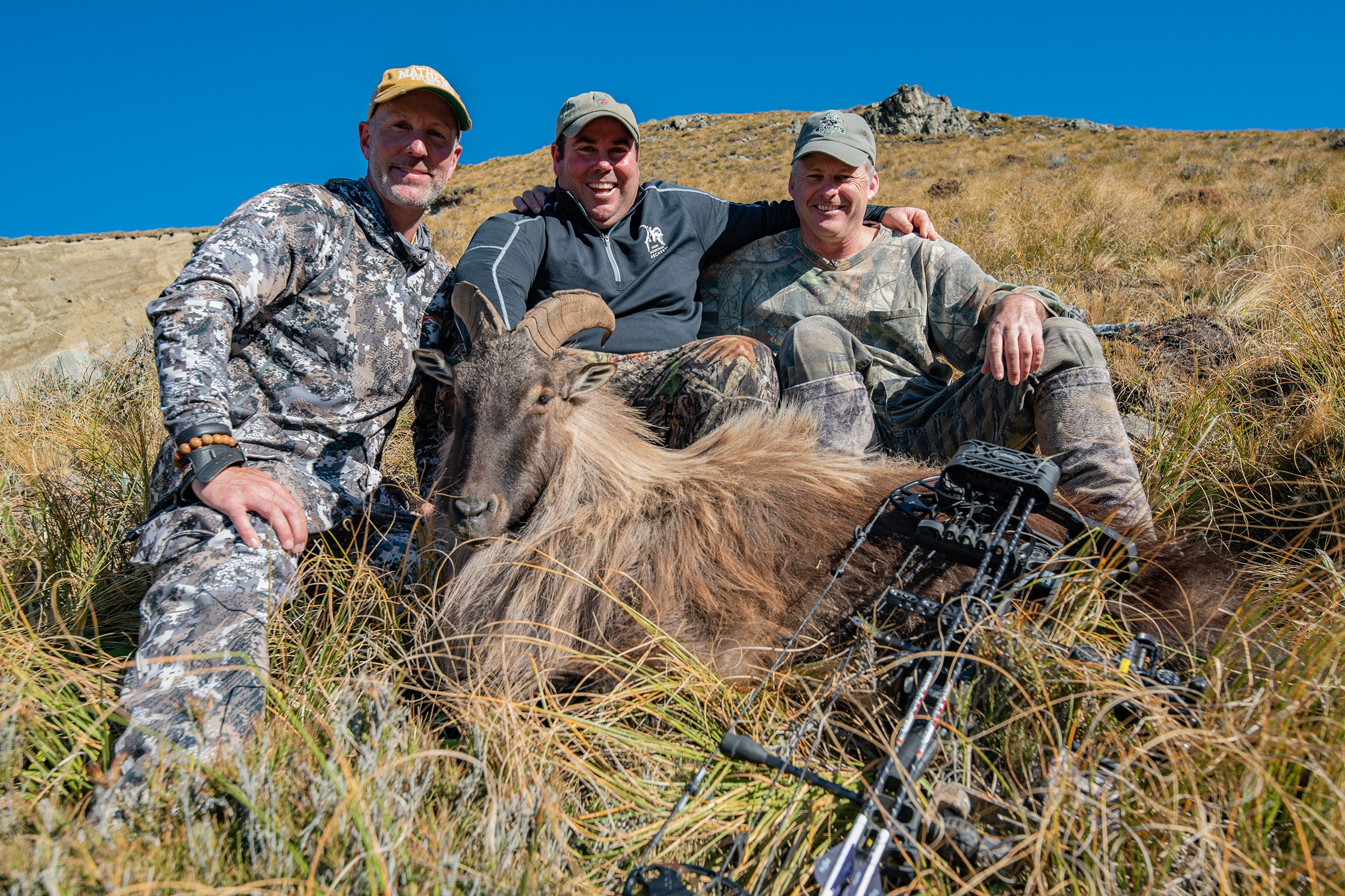 Rob, Rody, and Colin sit behind Rob's second and biggest bull tahr in New Zealand