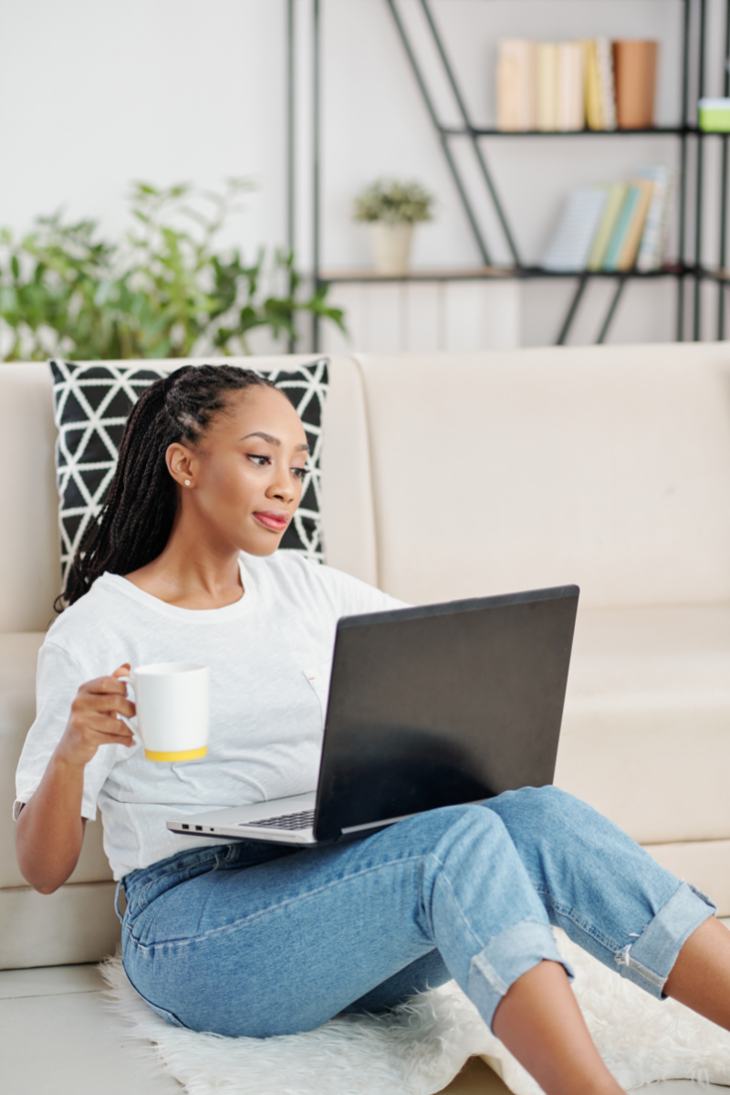 Woman on laptop drinking from mug